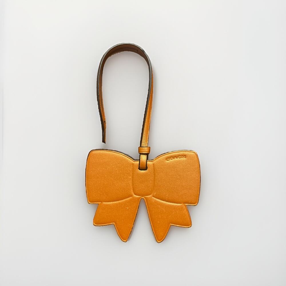 Coach F23558 Bow Ornament Bag Charm Orange Gold Metallic Leather 3.5”